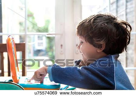 Toddler boy using toy laptop View Large Photo Image Stock Photo - Toddler boy using toy laptop. Fotosearch