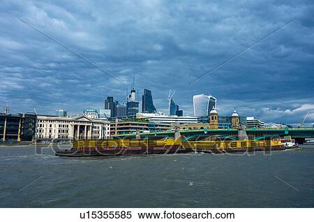 Stock Photography - Tug towing barges down River Thames, London, England, UK. Fotosearch