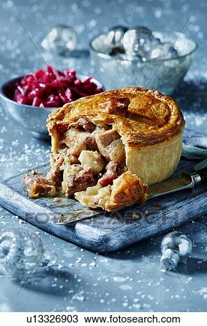 Stock Image - Turkey pie on cutting board, seasonal Christmas food. Fotosearch