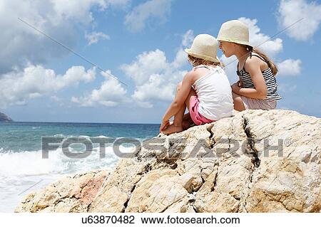 Two girls looking out at sea from rock, Scopello, Sicily, Italy View Large Photo Image Stock Image - Two girls looking out at sea from rock, Scopello, Sicily, Italy. Fotosearch