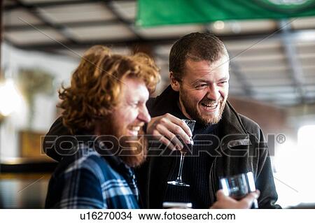 Picture - Two male customers laughing in traditional Irish public house. Fotosearch