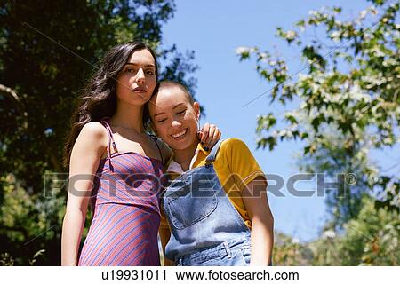 Stock Image - Two young female friends in park, portrait, Los Angeles, California, USA. Fotosearch
