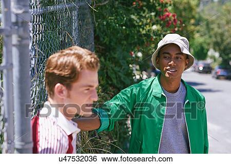 Two young men on suburban sidewalk, Los Angeles, California, USA View Large Photo Image Stock Photograph - Two young men on suburban sidewalk, Los Angeles, California, USA. Fotosearch