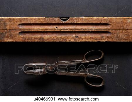 Stock Image - Vintage spirit level and scissors, overhead view. Fotosearch