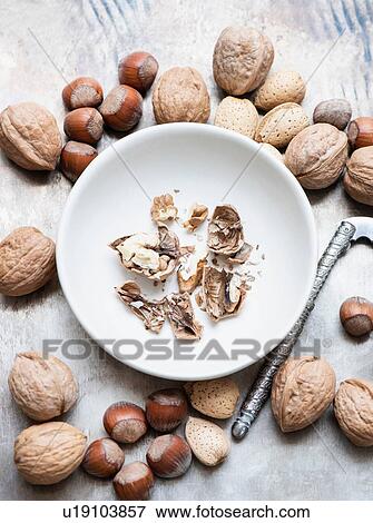 Stock Photo - Walnuts and almonds in shell, hazelnuts, cracked walnut in bowl. Fotosearch