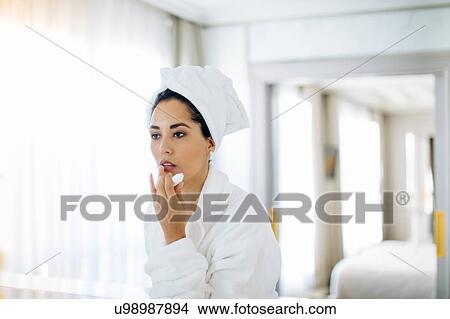 Woman applying lip balm in suite View Large Photo Image Picture - Woman applying lip balm in suite. Fotosearch