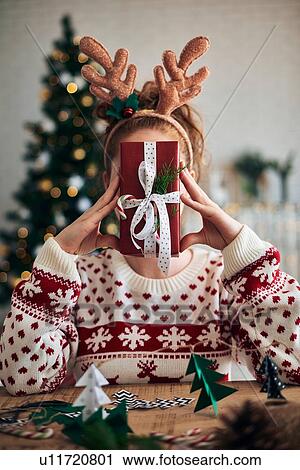 Woman behind Christmas present, Christmas tree shaped decorations in foreground View Large Photo Image Stock Image - Woman behind Christmas present, Christmas tree shaped decorations in foreground. Fotosearch