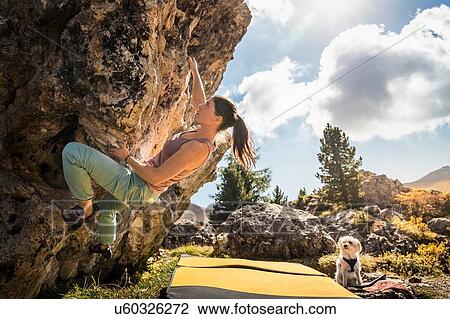Stock Image - Woman bouldering with her dog watching, Citt dei Sassi or Steinerne Stadt, Dolomites. Fotosearch