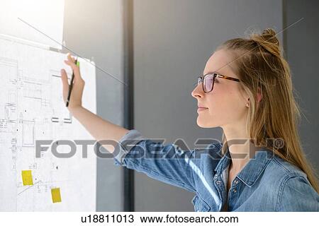 Woman contemplating plans on glass wall View Large Photo Image Stock Image - Woman contemplating plans on glass wall. Fotosearch
