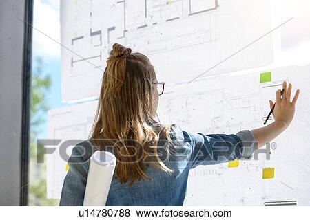 Woman contemplating plans on glass wall View Large Photo Image Stock Photo - Woman contemplating plans on glass wall. Fotosearch