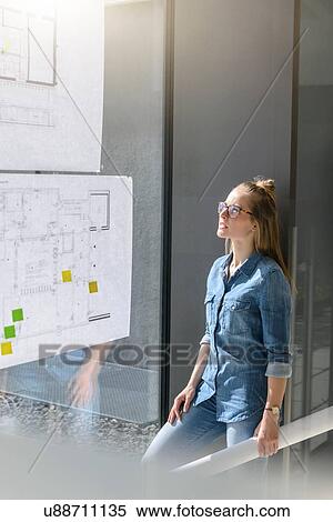 Woman contemplating plans on glass wall View Large Photo Image Stock Photography - Woman contemplating plans on glass wall. Fotosearch