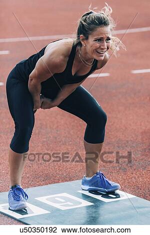 Stock Image - Woman doing kettle bell swing. Fotosearch