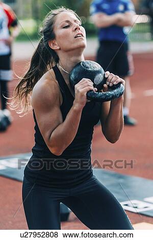 Stock Photo - Woman doing kettle bell swing. Fotosearch