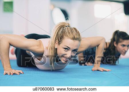 Stock Image - Woman doing push up. Fotosearch