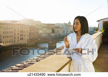 Stock Image - Woman having coffee on hotel balcony, Florence, Toscana, Italy. Fotosearch