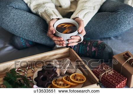 Woman having warm drink in front of tray of Christmas biscuits and gifts View Large Photo Image Stock Image - Woman having warm drink in front of tray of Christmas biscuits and gifts. Fotosearch