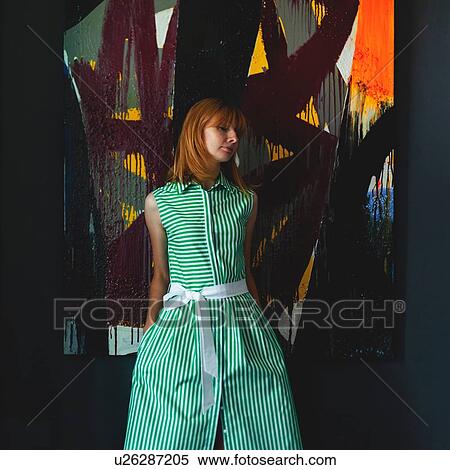 Stock Photography - Woman in green summer dress beside modern painting. Fotosearch
