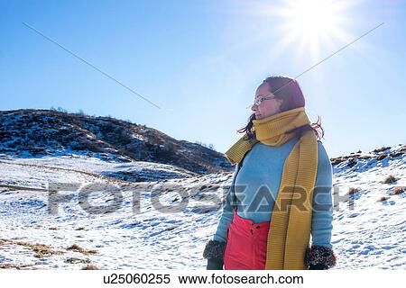 Stock Photography - Woman in snow landscape, Piani Resinelli, Lombardy, Italy. Fotosearch