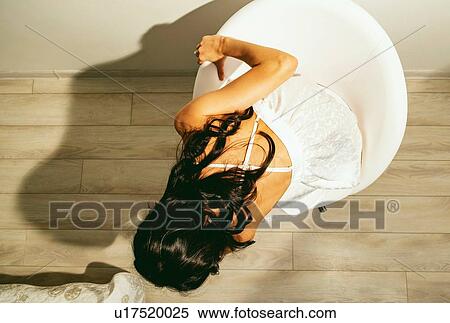 Stock Photography - Woman in summer dress sitting chair. Fotosearch
