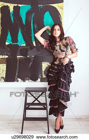 Woman in tiered dress beside modern painting View Large Photo Image Stock Photo - Woman in tiered dress beside modern painting. Fotosearch