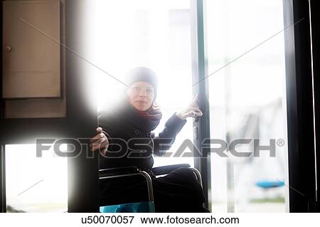 Woman in wheelchair entering building View Large Photo Image Stock Photo - Woman in wheelchair entering building. Fotosearch
