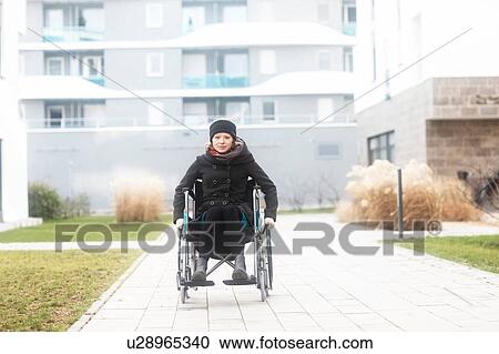 Woman in wheelchair in residential area View Large Photo Image Stock Image - Woman in wheelchair in residential area. Fotosearch