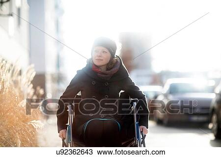 Woman in wheelchair in street View Large Photo Image Stock Image - Woman in wheelchair in street. Fotosearch