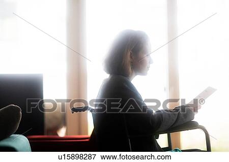 Stock Photo - Woman in wheelchair reading. Fotosearch