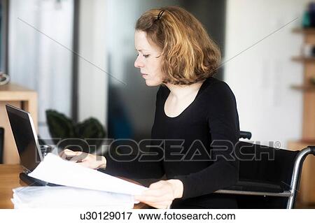Woman in wheelchair working at laptop View Large Photo Image Stock Photo - Woman in wheelchair working at laptop. Fotosearch