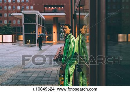 Woman leaning against glass window, Milan, Italy View Large Photo Image Picture - Woman leaning against glass window, Milan, Italy. Fotosearch