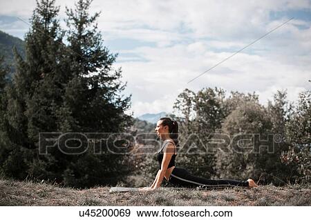 Woman practicing yoga, on yoga mat in rural landscape View Large Photo Image Stock Photo - Woman practicing yoga, on yoga mat in rural landscape. Fotosearch