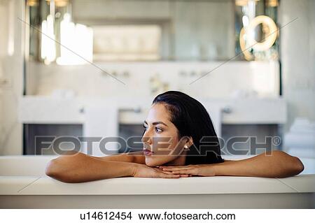 Picture - Woman relaxing in bathtub in suite. Fotosearch