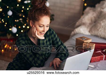 Woman shopping for Christmas presents online View Large Photo Image Stock Photograph - Woman shopping for Christmas presents online. Fotosearch