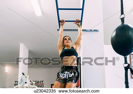 Woman swinging along monkey bars gym View Large Photo Image Stock Photography - Woman swinging along monkey bars gym. Fotosearch