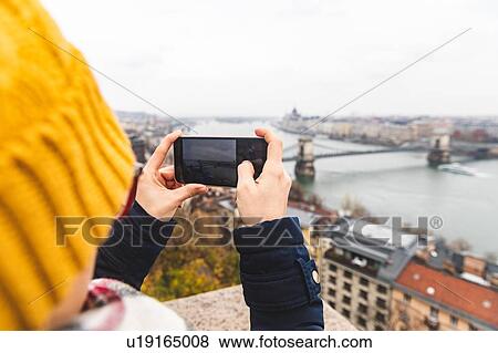Stock Photo - Woman taking photograph of view, Budapest, Hungary. Fotosearch