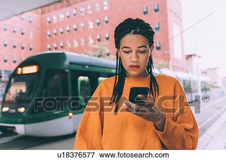 Woman texting at tram stop, Milan, Italy View Large Photo Image Stock Photo - Woman texting at tram stop, Milan, Italy. Fotosearch