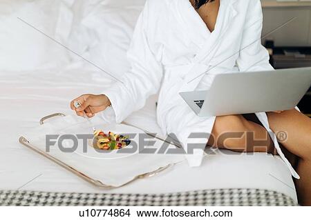 Woman using laptop and having breakfast in suite View Large Photo Image Picture - Woman using laptop and having breakfast in suite. Fotosearch