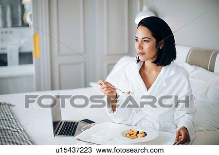 Woman using laptop and having breakfast in suite View Large Photo Image Stock Image - Woman using laptop and having breakfast in suite. Fotosearch