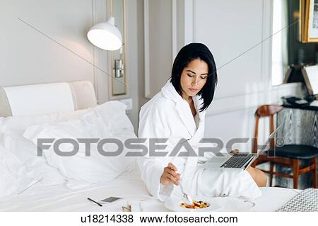 Woman using laptop and having breakfast in suite View Large Photo Image Stock Photo - Woman using laptop and having breakfast in suite. Fotosearch