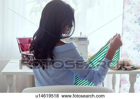 Woman using sewing machine beside window View Large Photo Image Stock Photo - Woman using sewing machine beside window. Fotosearch
