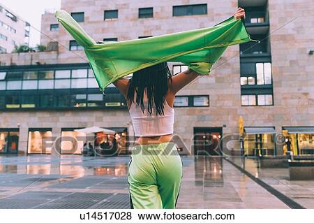 Stock Photo - Woman welcoming rain in town square, Milan, Italy. Fotosearch