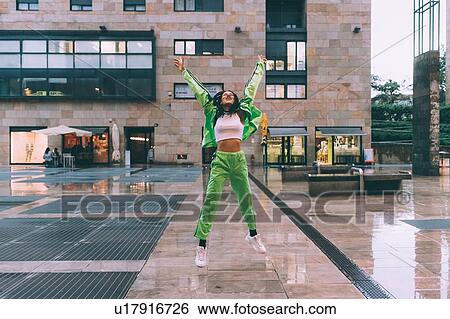 Stock Photograph - Woman welcoming rain in town square, Milan, Italy. Fotosearch