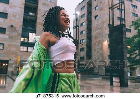 Stock Photography - Woman welcoming rain in town square, Milan, Italy. Fotosearch