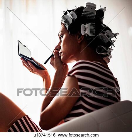Woman with hair-rollers putting on make up View Large Photo Image Stock Photograph - Woman with hair-rollers putting on make up. Fotosearch