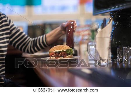 Woman with plate of burger on pub counter top View Large Photo Image Stock Image - Woman with plate of burger on pub counter top. Fotosearch