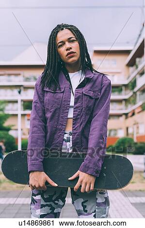 Stock Image - Woman with skateboard, Milan, Italy. Fotosearch