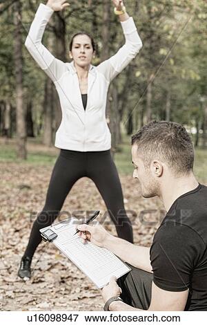 Stock Photo - Woman working out with personal trainer. Fotosearch