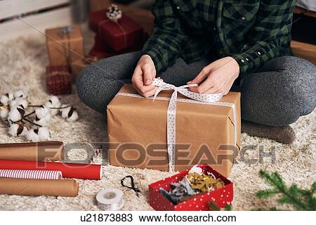 Stock Image - Woman wrapping Christmas presents. Fotosearch