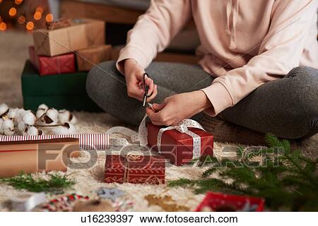 Stock Photo - Woman wrapping Christmas presents. Fotosearch