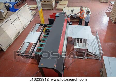 Stock Image - Workers printing cardboard boxes in cardboard box factory. Fotosearch